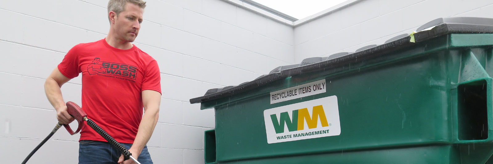 power washing the grime from a dumpster pad