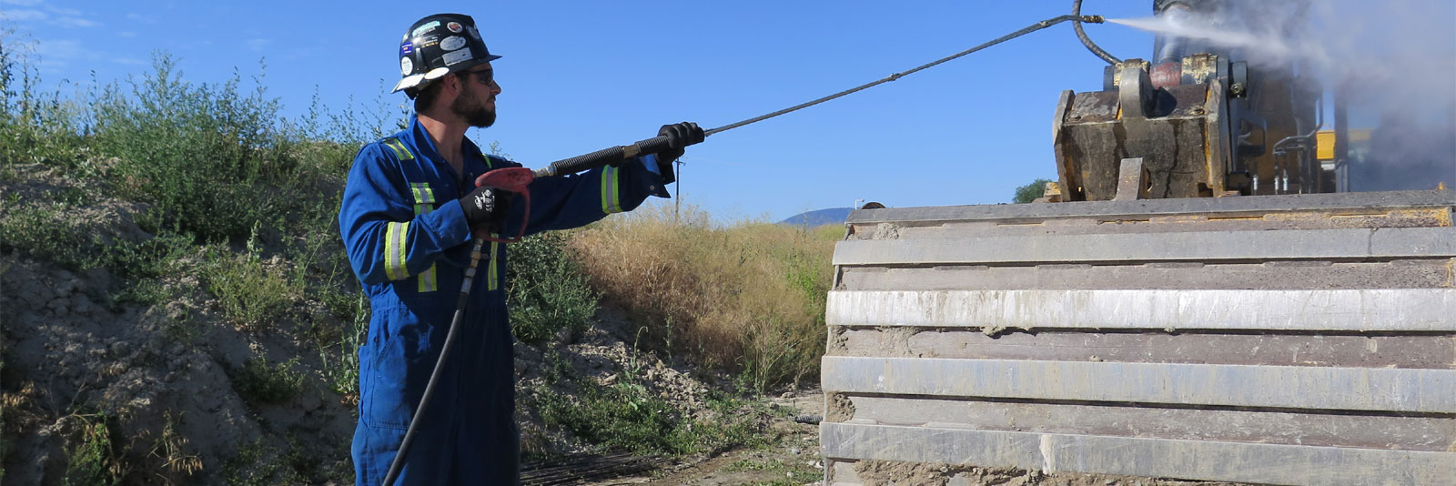 BOSSWASH employee power washing heavy equipment